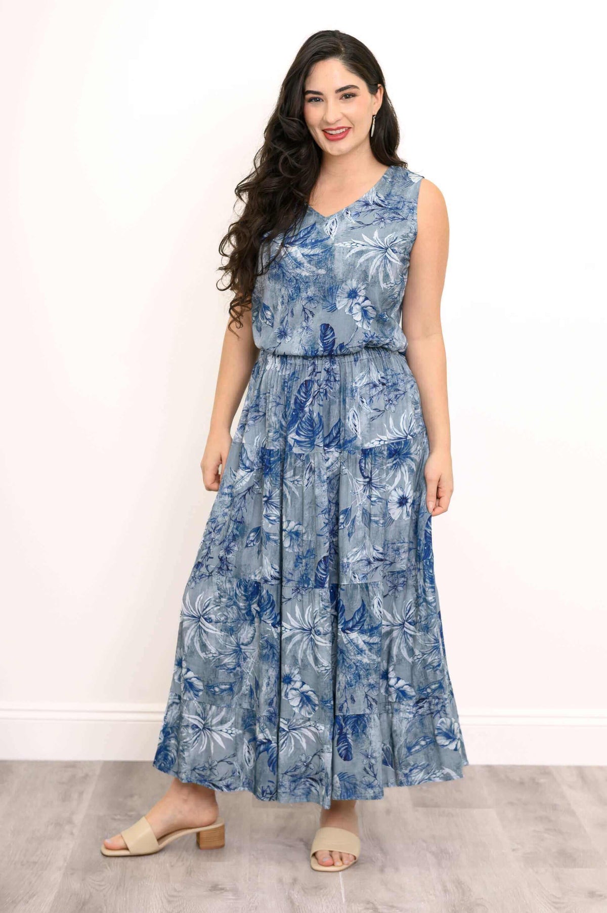 Model smiling in blue floral sleeveless tiered skirt outfit