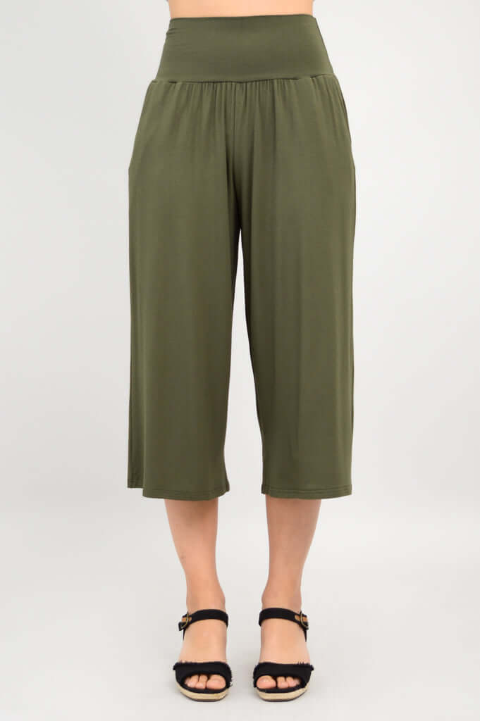Model standing in olive green bamboo palazzo capri pants, neutral background