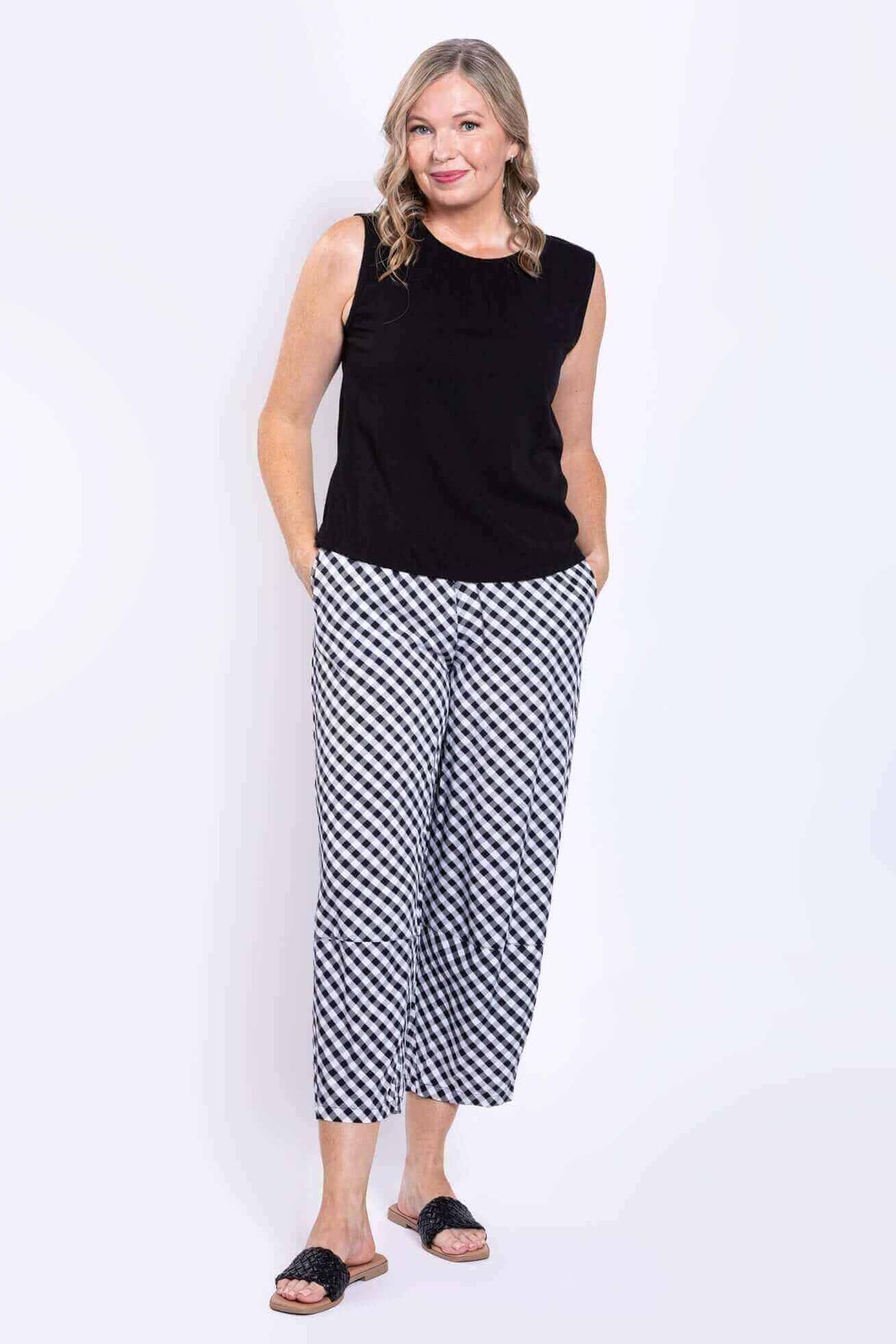 Full body view of model in black Nina tank and black-and-white check pants
