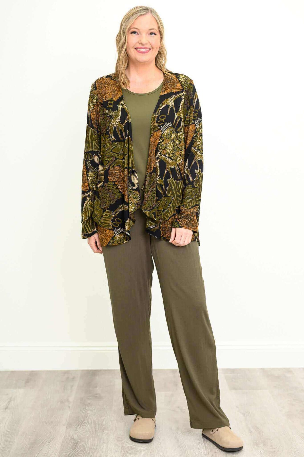 Model wearing olive bamboo linen trousers with a patterned jacket