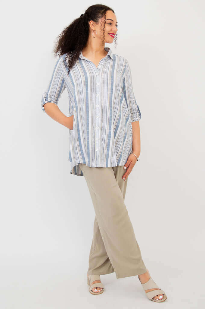 Model in blue and white striped tunic shirt paired with beige wide-leg pants