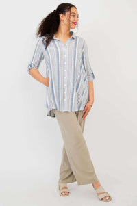 Model in blue and white striped tunic shirt paired with beige wide-leg pants