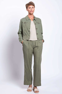 Full body view of model in olive pants and jacket, hands in pockets
