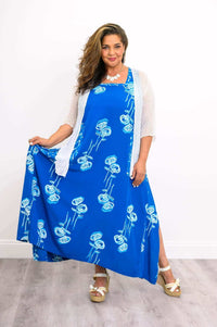 Model styling a flowy blue floral dress with white cardigan, showcasing movement