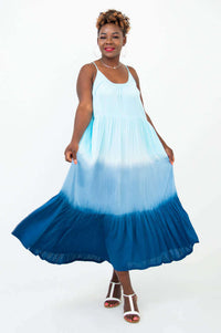 Woman posing and swirling in a blue ombre maxi dress, playful look