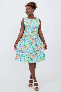 Model twirling in a blue sleeveless floral dress with ruched bodice