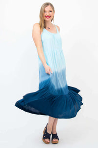 Woman twirling in a flowing ombre blue maxi dress, showing movement