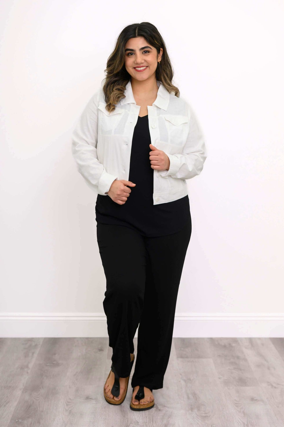 Model walking confidently in white linen jean jacket, hands by her sides