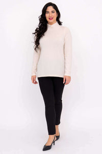 Model walking forward in cream Simmon Sweater and black heels