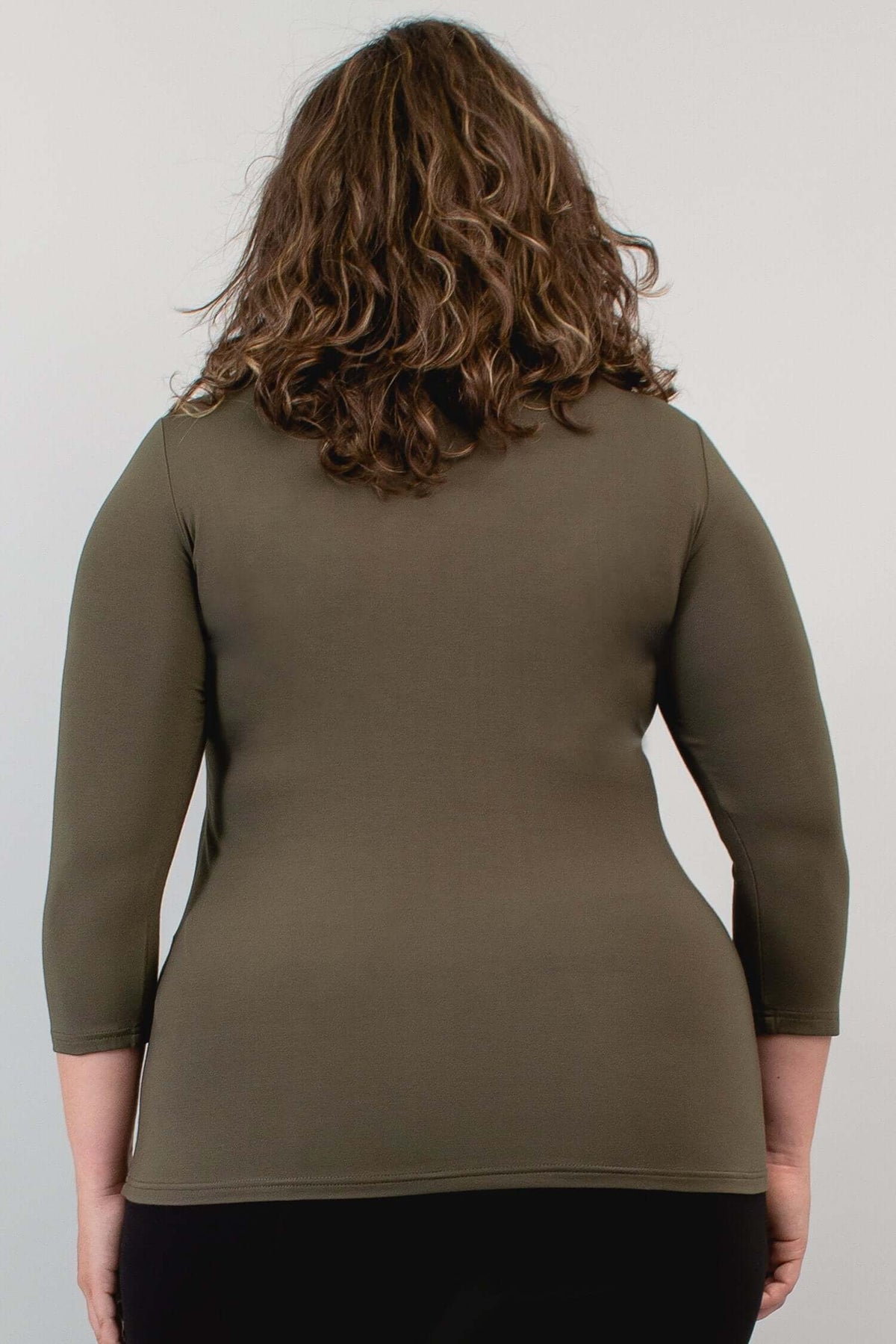 Model walking forward in olive bamboo top and black pants, front view
