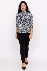 Model walking forward in animal print Highdrop Top and black pants