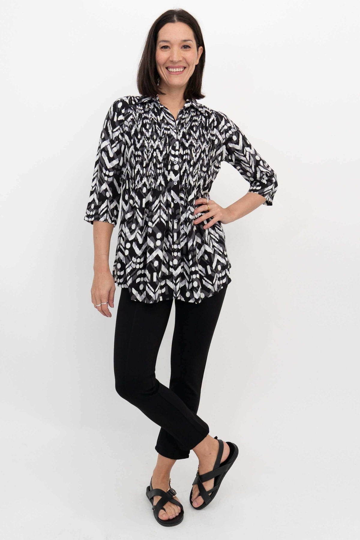 Woman posing in black and white Ikat blouse with 3/4 sleeves, front view