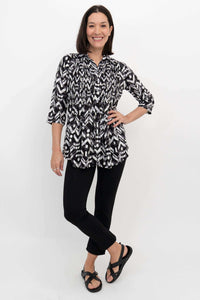 Woman posing in black and white Ikat blouse with 3/4 sleeves, front view