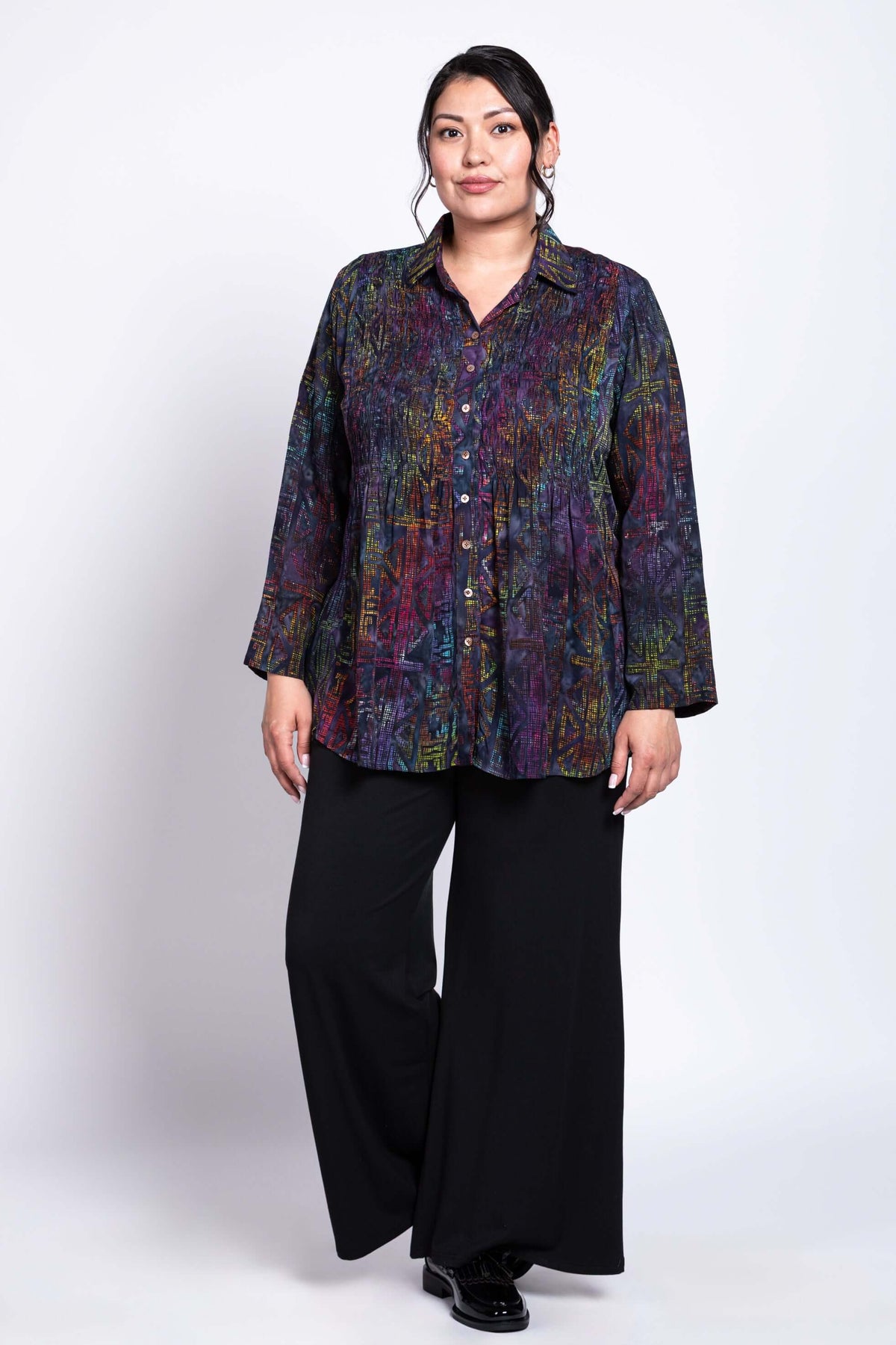 Full body side view of model in Cindy smocked shirt and wide-leg black pants