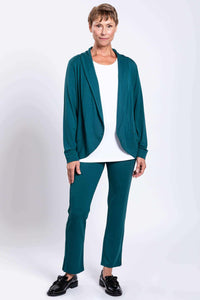 Model wearing teal bamboo pant and matching jacket, styled with black shoes and white top