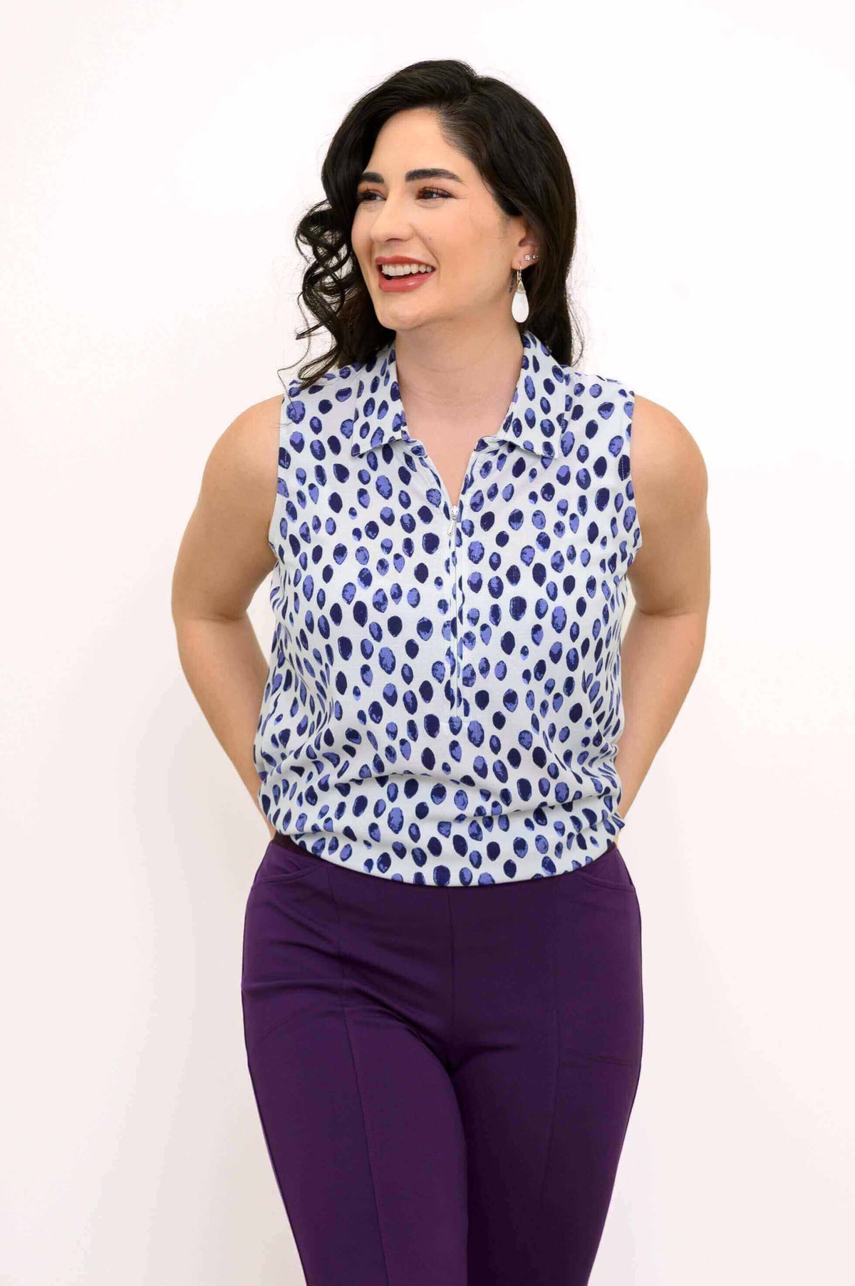 Model wearing The Hula sleeveless blue spotted tank top and smiling