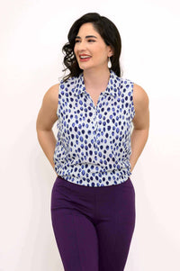 Model wearing The Hula sleeveless blue spotted tank top and smiling