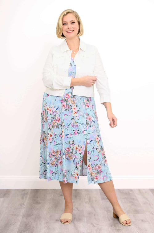 Model wearing a blue floral sleeveless dress with white cropped jacket