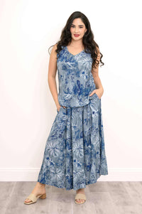 Model wearing a blue floral sleeveless top and matching tiered skirt