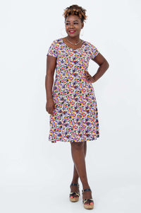Model wearing a colorful floral short sleeve A-line dress with pockets