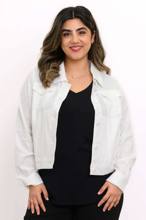 Model wearing a white linen-blend jean jacket over a black top, smiling at the camera