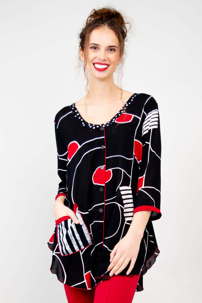 Model wearing black and red Aku Top with unique batik art and striped pocket, close view