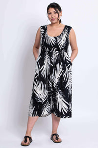 Model wearing black and white leaf print jumpsuit with pockets, front view
