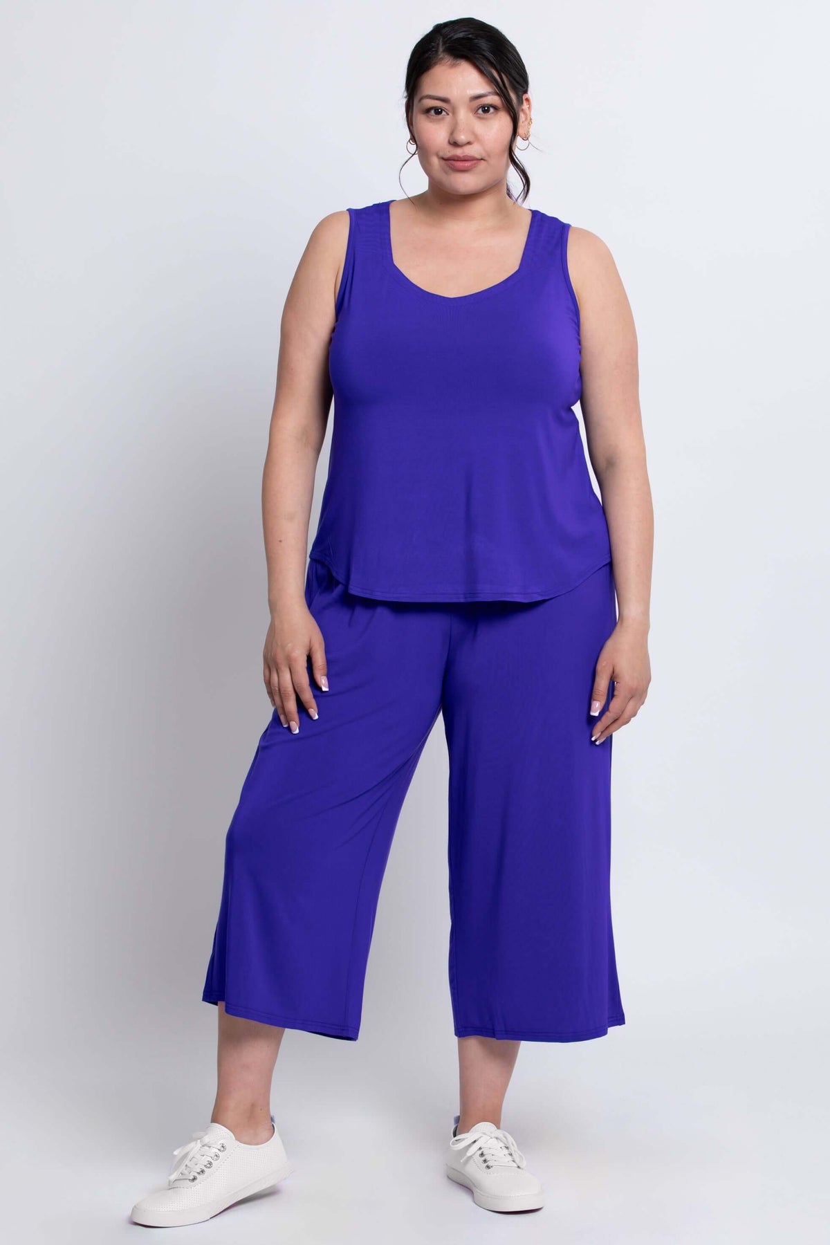 Model wearing blue capri pants and matching top, front view