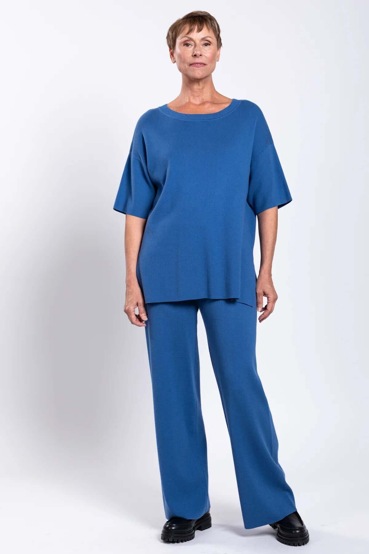 Model in blue relaxed-fit top and straight-leg pants, front view