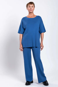 Model in blue relaxed-fit top and straight-leg pants, front view