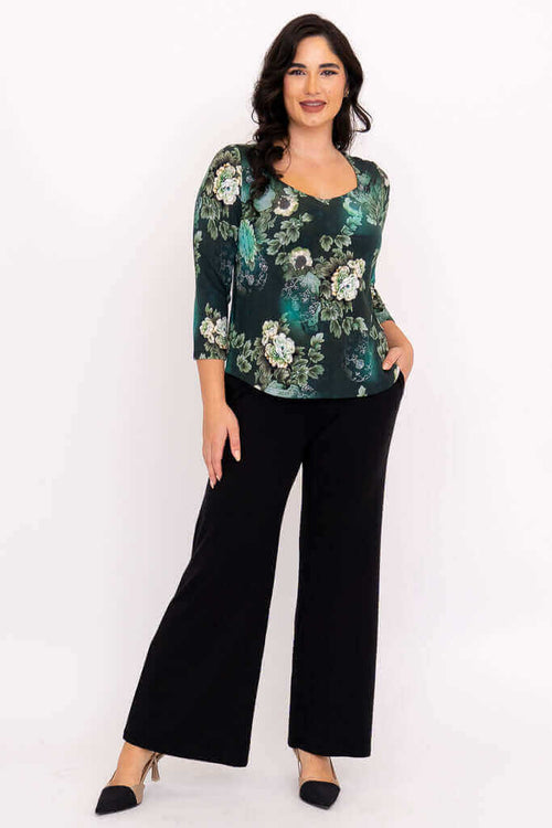 Full front view of model in green floral top with black wide-leg pants
