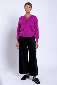 Full view of woman in magenta wool cashmere hoodie and black wide-leg pants