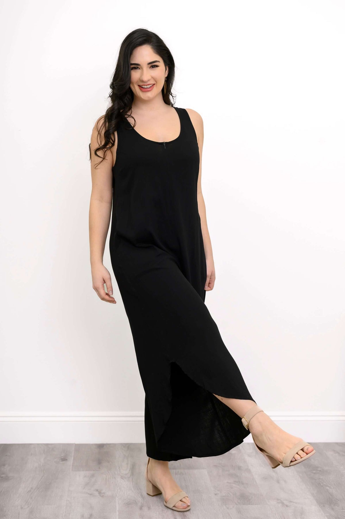 Model in black jumpsuit with front zip, stepping forward playfully