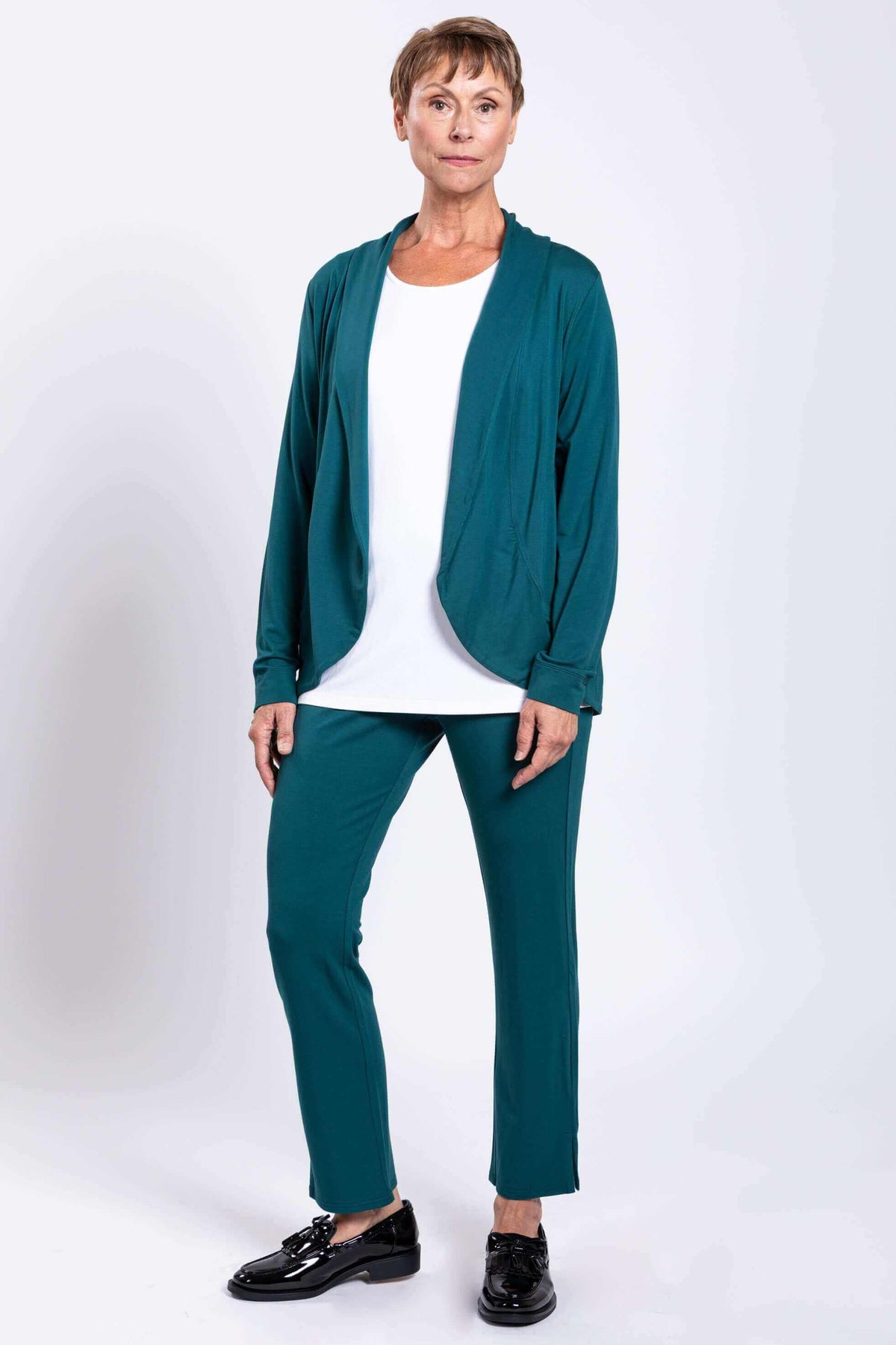 Woman in teal French Terry jacket, matching pants, and black shoes, front view