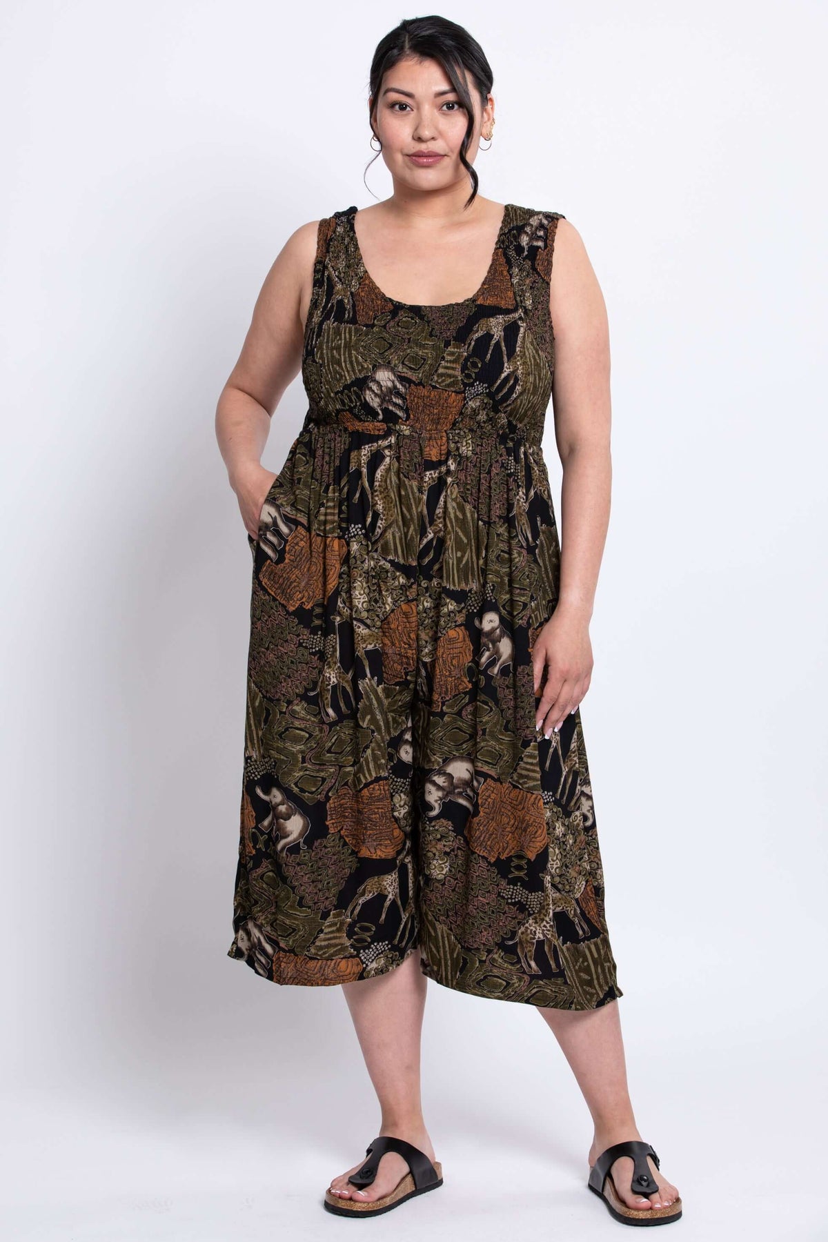 Model wearing a wide-leg sleeveless jumpsuit with an animal print pattern, hands in pockets