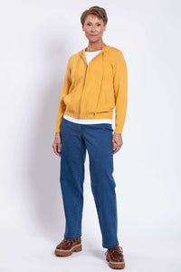 Front view of a woman wearing a relaxed fit mustard yellow long sleeve zip hoodie in studio.