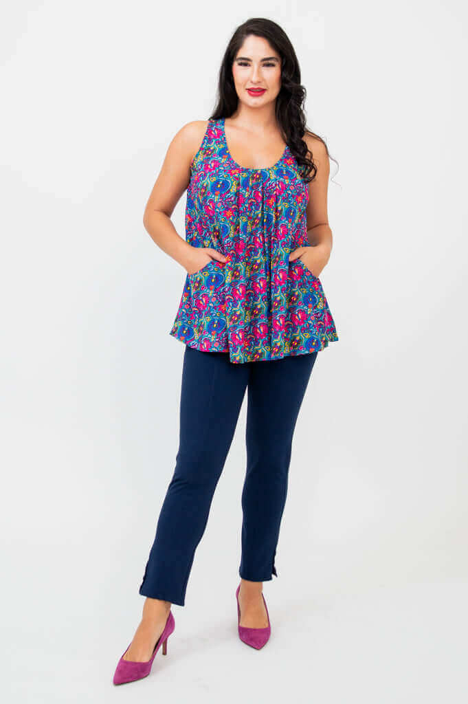Model with hands in pockets of Peachy pleated tank top and navy pants, standing confidently