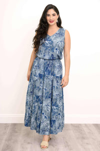 Model with hands in pockets wearing matching blue floral V-neck tank and skirt