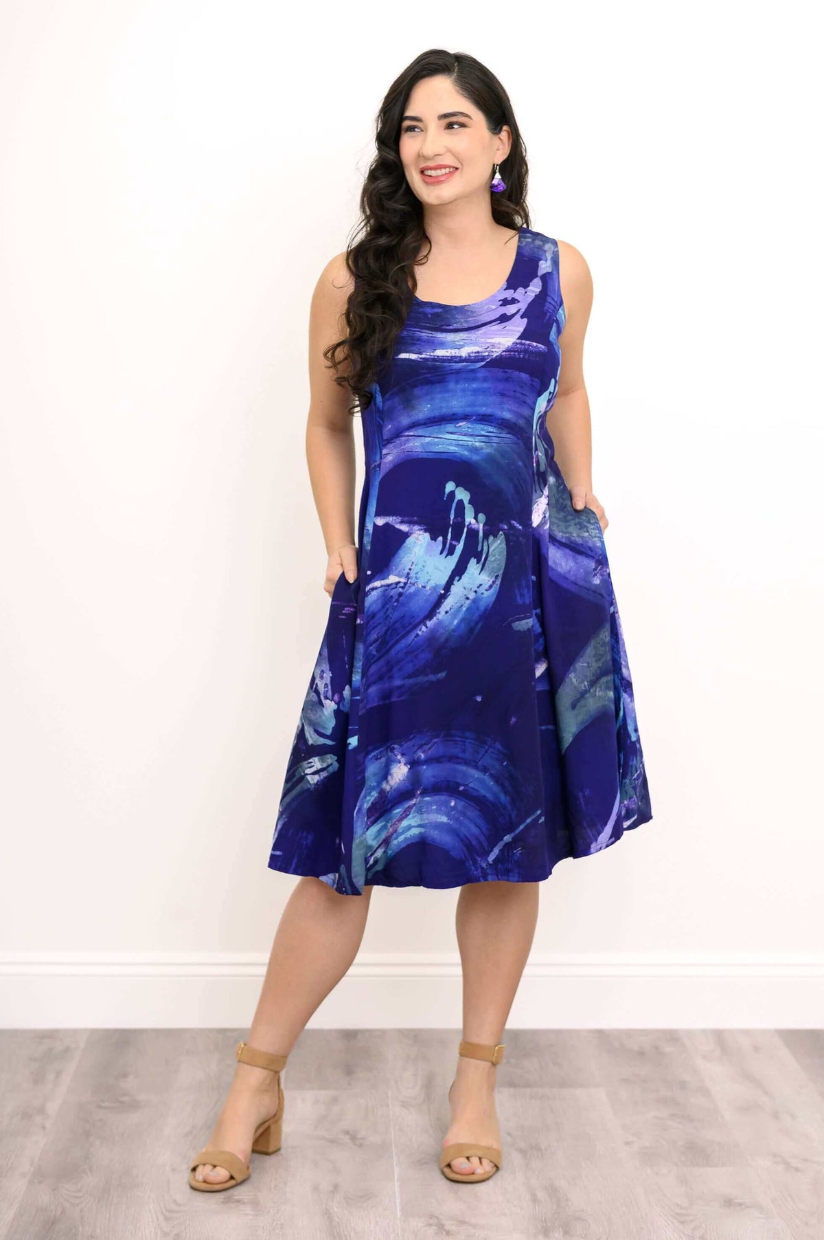 Model showing side pockets of the Azure Swirl Sleeveless Dress in blue abstract design