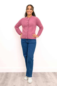 Front view of a woman wearing a comfortable pink 100% cashmere cable knit cardigan with shell buttons.