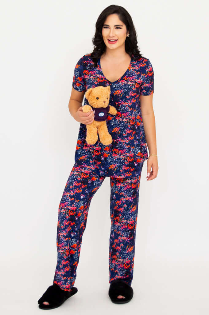 Model holding teddy bear and smiling in matching floral bamboo lounge set