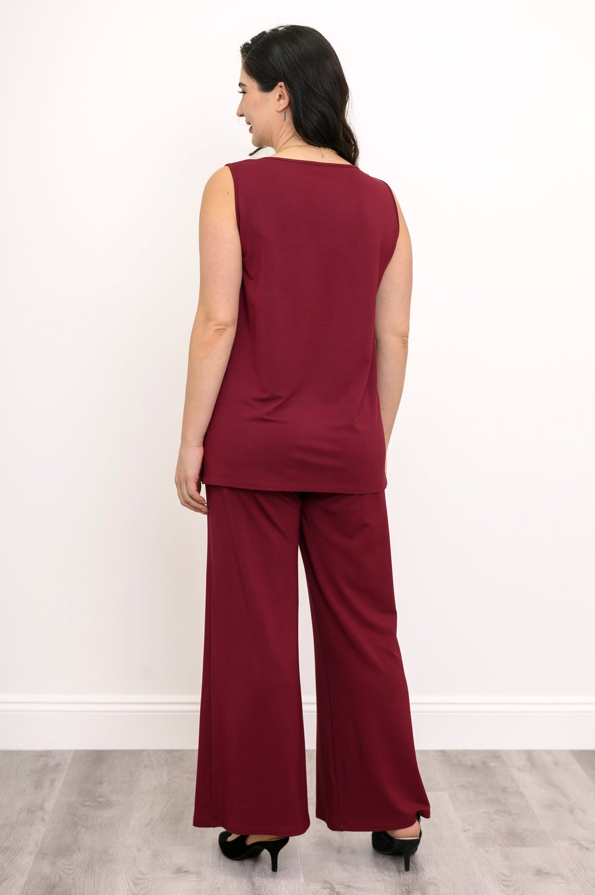 Back view of a woman wearing a burgundy sleeveless knit tank top paired with matching wide-leg pants.