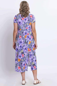 Back view of woman wearing a purple floral dress with back slit