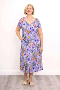 Woman wearing a purple floral short sleeve dress with side slits and pockets