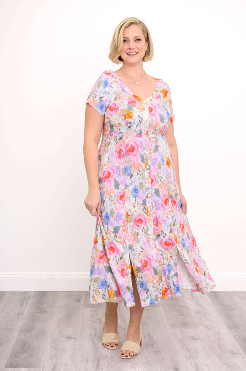 Woman wearing a colorful floral midi dress with button front and side slits