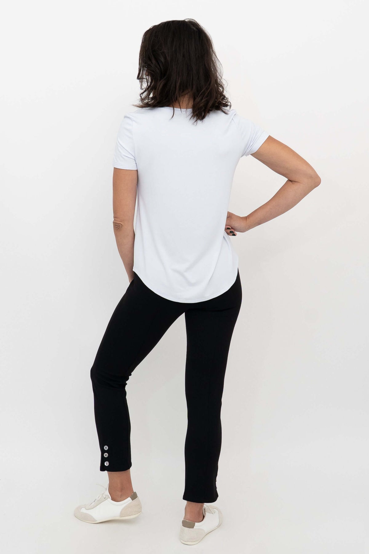 Back view of a model wearing the Nadine Crop Pant, highlighting the button detail at the hem