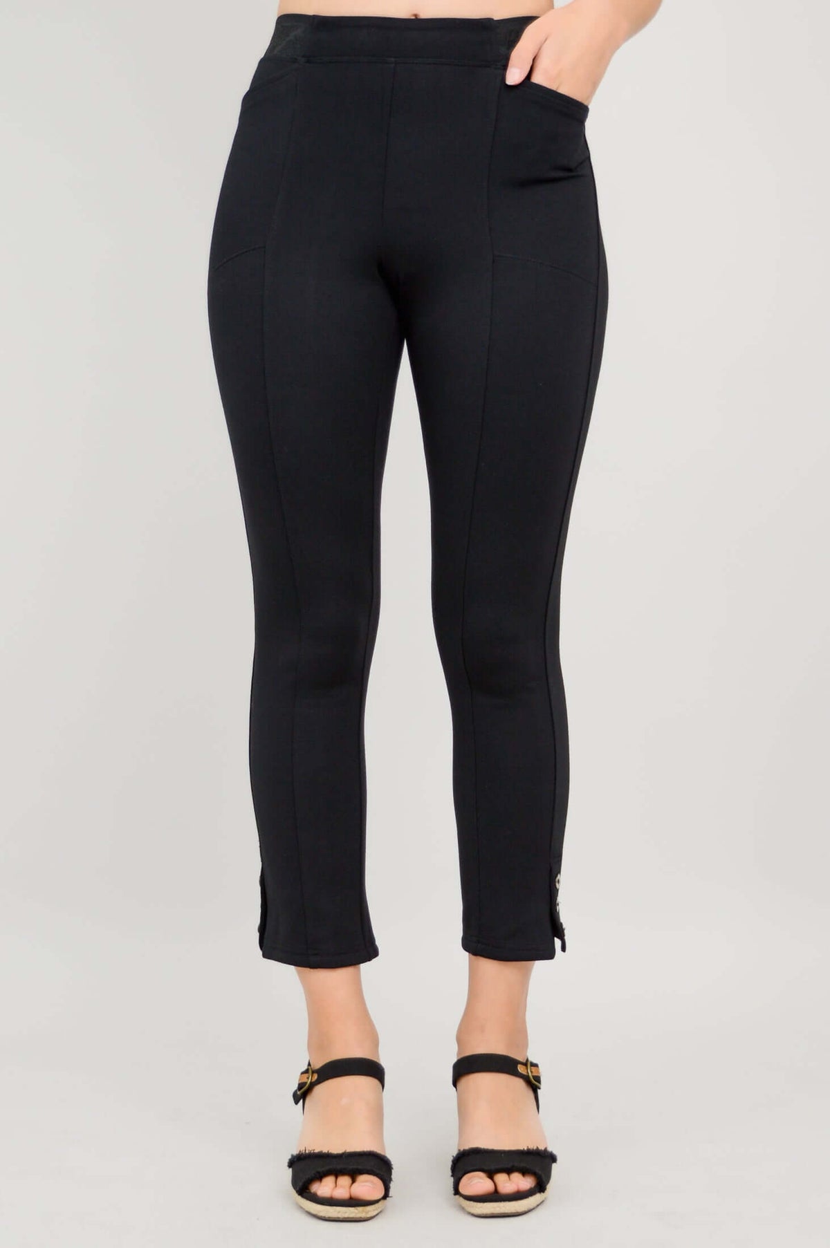 Front view of the Nadine Crop Pant in black with a hand in the pocket, showing button and pocket details