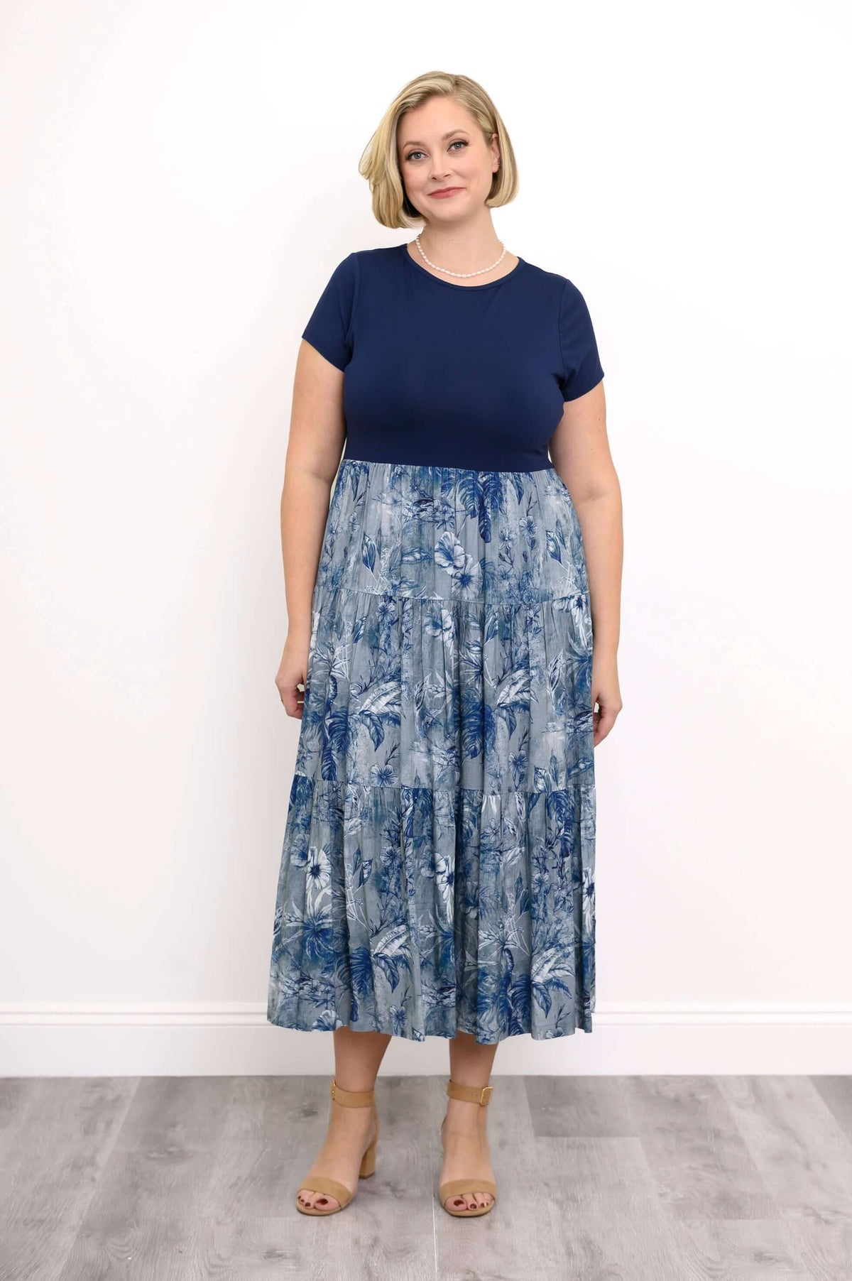 Woman wearing a navy and blue floral print midi dress with short sleeves
