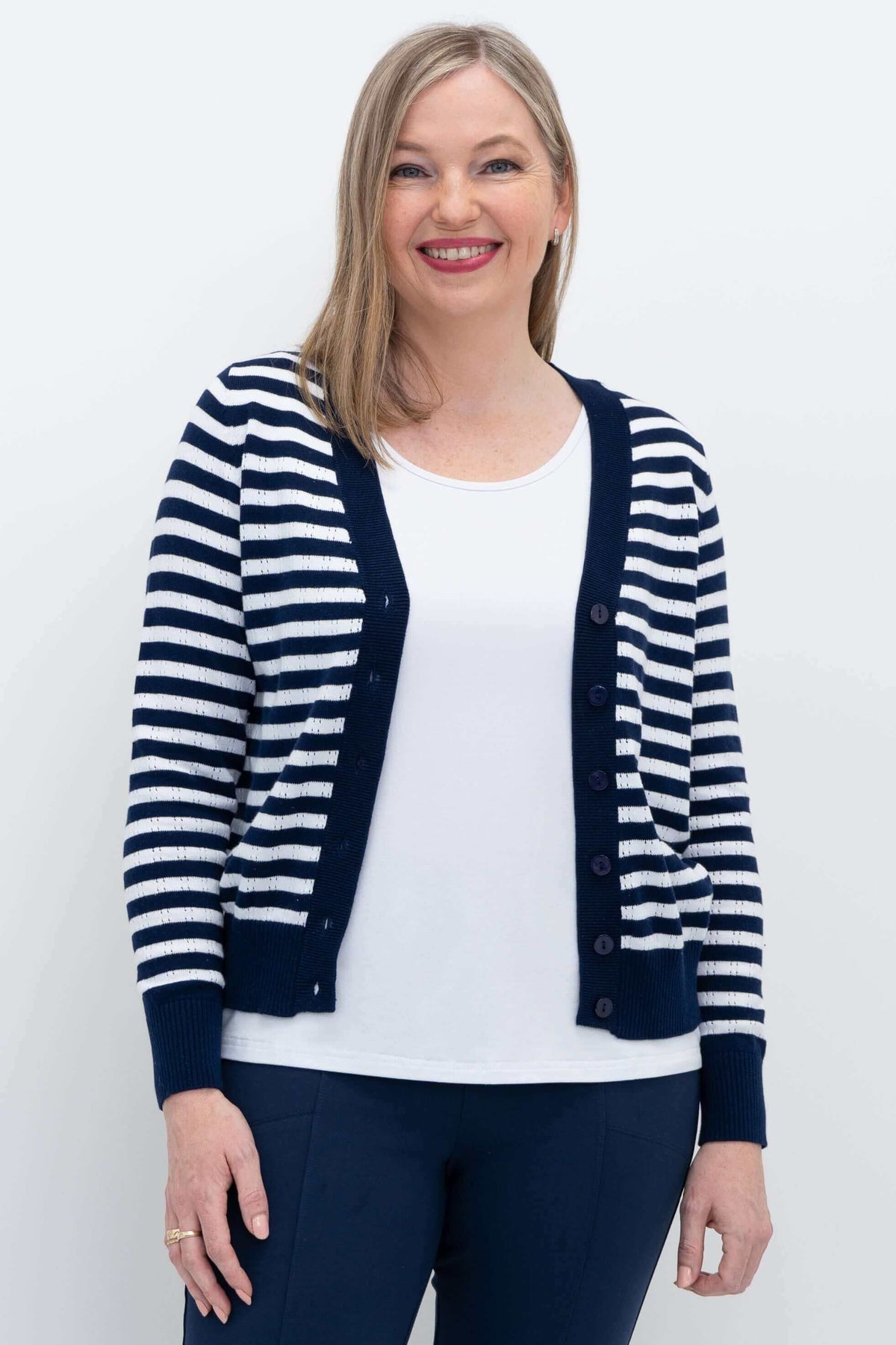 Woman wearing a navy and white Breton striped cotton cardigan, front view