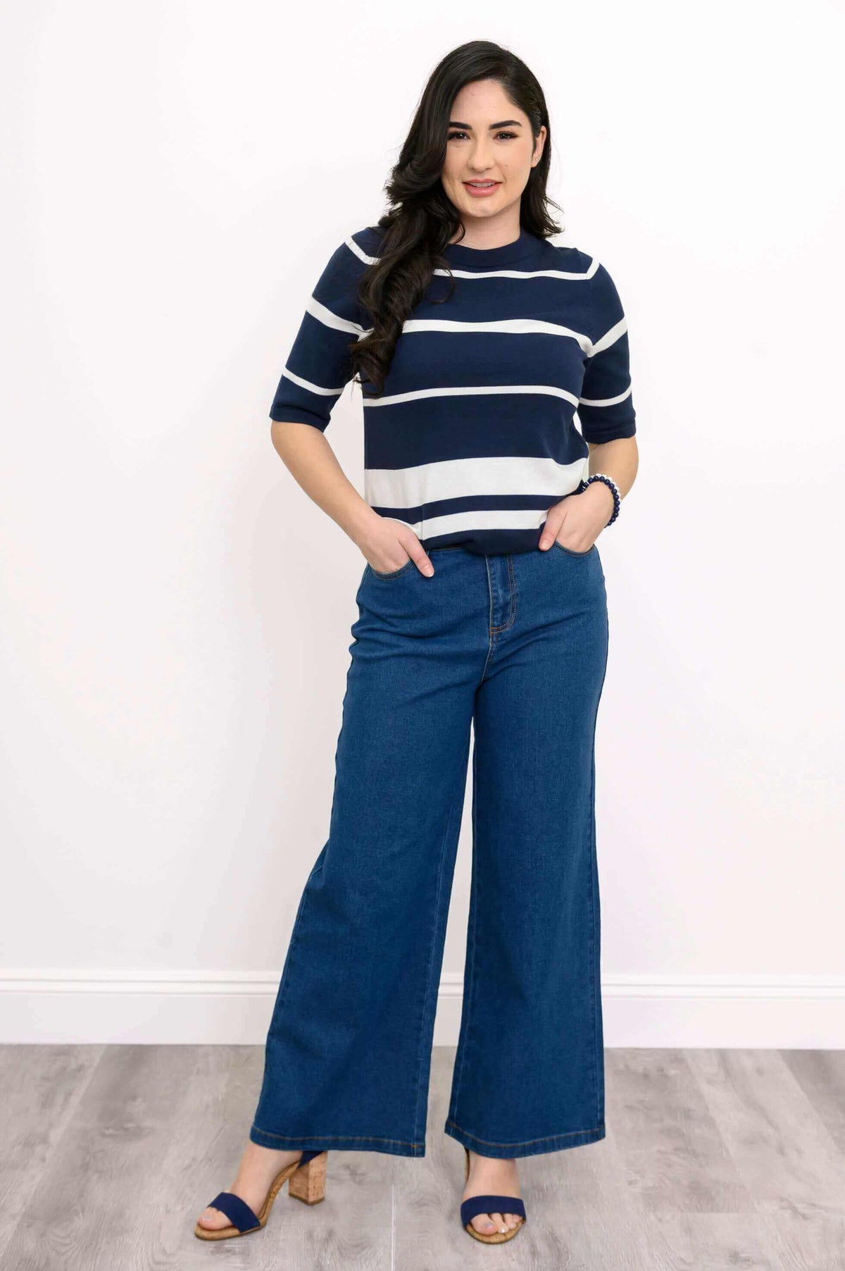 Woman modeling navy and white striped cotton sweater with hands in pockets